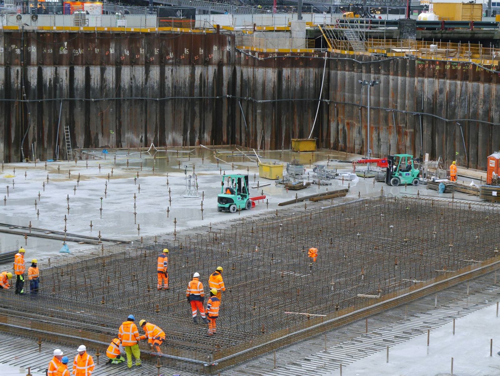 Workers fixing steel reinforcement for a foundation slab